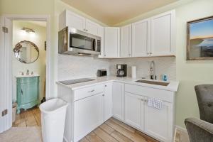 a kitchen with white cabinets and a sink at Assateague Inn 206-S in Chincoteague