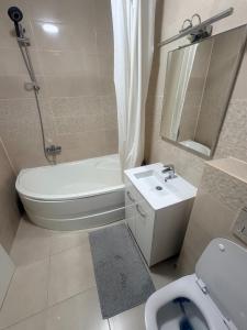 a bathroom with a white toilet and a sink at Modern Flat Near Bucharest in residence in Dobroeşti