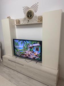 a flat screen tv sitting on a stand in a living room at Modern Flat Near Bucharest in residence in Dobroeşti