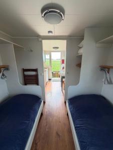 two beds in a small room with a hallway at Horns Skärgårdscamping in Nyköping +16 photos