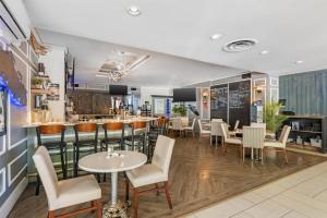 a restaurant with a bar and tables and chairs at Best Western Dorchester Hotel in Nanaimo