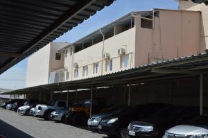 a row of cars parked in front of a building at Hotel Rio Claro in Rio Claro
