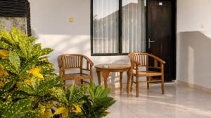 two chairs and a table in a room at Cahaya Adrian Hotel in Labuan Bajo