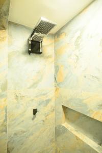 a shower in a bathroom with a marble wall at Desfrute Pousada e Experiencia in Arraial d'Ajuda