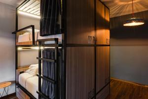 a room with a bunk bed and a room with a table at Bendito Hostels in Bogotá