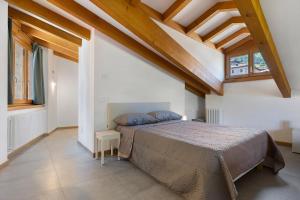 a bedroom with a bed in a room with wooden ceilings at Casa Zucchelli in Tenno