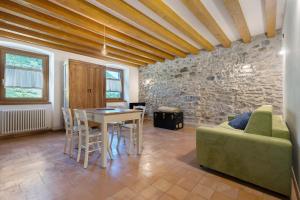 a living room with a green couch and a table at Casa Zucchelli in Tenno