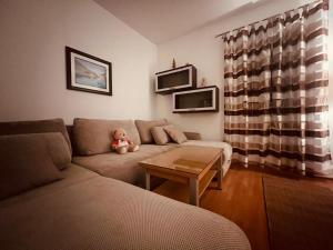 a living room with a couch and a teddy bear at Apartments Klara in Donja Lastva