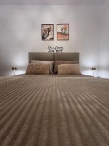 a bedroom with a large bed and two pictures on the wall at Apartments Klara in Donja Lastva