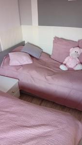 a pink bed with a stuffed teddy bear on it at Domek Agroturystyczny Doris in Stężyca