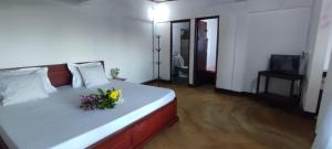 a bedroom with a white bed with flowers on it at Maisonnette en bord de mer in Antsiranana