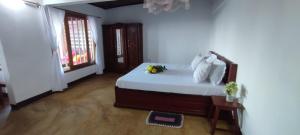 a bedroom with a bed with white sheets and a window at Maisonnette en bord de mer in Antsiranana