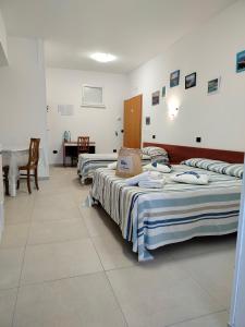 a group of beds in a room with a table at B&B Gattopardo in Cariati +47 photos