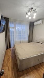 a bedroom with a bed and a large window at Elena Relax Apartment in Varna City