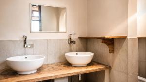 a bathroom with two sinks and a mirror at Cahaya Adrian Hotel in Labuan Bajo