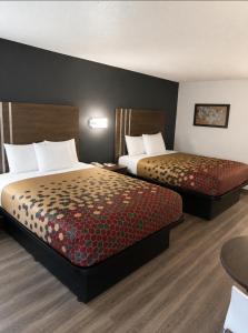 a hotel room with two beds and a table at Econo Lodge Calhoun South in Calhoun