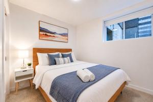 a white bedroom with a large bed and a window at Jolie Condo Great Location 2BD presented by TripMontreal I in Montreal