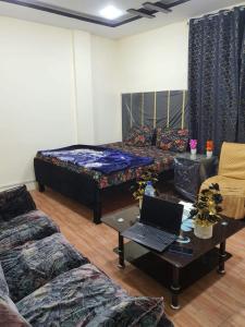 a living room with a couch and a laptop on a table at New aalbayan hotel in Lahore +6 photos