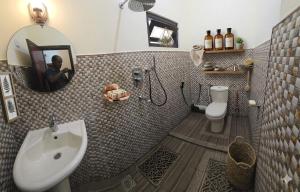 a bathroom with a sink and a toilet and a mirror at Beach Guest House Addalaichenai in Addalachenai +14 photos