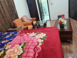 a red blanket with flowers on top of a bed at New aalbayan hotel in Lahore