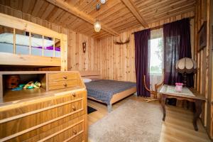 a bedroom with a bed and a desk in a cabin at Kuberi Retro Holiday Home I Sauna Possibility in Pedja