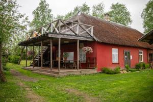 a red house with a thatched roof at Kuberi Retro Holiday Home I Sauna Possibility in Pedja