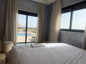 a bedroom with a bed and a view of a pool at Villa neuve pour un séjour agréable à Essaouira in Essaouira +70 photos