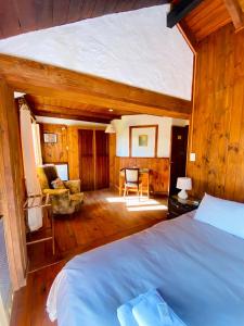 a bedroom with a bed and a chair in a room at Hosteria Las Cartas in San Carlos de Bariloche