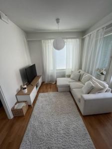 a living room with a white couch and a tv at Lapland home in Rovaniemi
