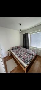 a bed in the corner of a room with a window at Lapland home in Rovaniemi