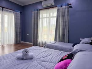 a bedroom with two beds with a stuffed animal on top of it at Teratak Chena - Lux Bungalow in Kuala Terengganu