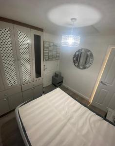 a room with a bed and a mirror on the wall at MK WhiteHouse cottage in Milton Keynes