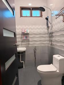 a bathroom with a toilet and a sink at Teratak Chena - Lux Bungalow in Kuala Terengganu +9 photos