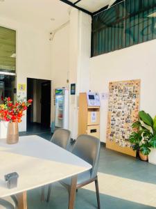 a table with chairs and a vase with flowers on it at START HOUSE AIRPORT 5-MIN WALK Warm Stay, Easy Flight in Ho Chi Minh City