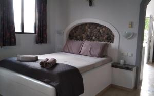 a bedroom with a bed with a large headboard at Endless BLUE Lahania in Lachania