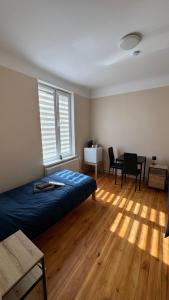 a bedroom with a bed and a table and chairs at Smilšu ielas Hostelis in Valmiera