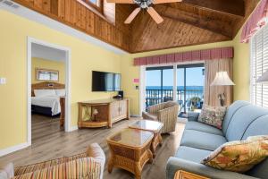 a living room with a blue couch and a bedroom at Soundside Holiday Beach Resort in Pensacola Beach