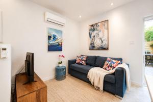 a living room with a blue couch and a tv at Jolie Condo Great Location 2BD presented by TripMontreal I in Montreal