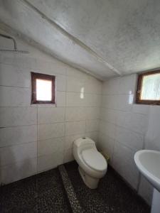 ein Badezimmer mit Toilette und Waschbecken in der Unterkunft Nacho's hotel in Soray