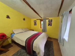 ein Schlafzimmer mit einem Bett in einem gelben Zimmer in der Unterkunft Nacho's hotel in Soray