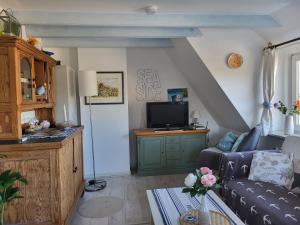a living room with a couch and a tv at Ferienwohnung Roman in Tinnum