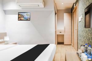 a hotel room with a bed and a table at Hotel O Sivalika Inn in Kolkata