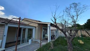 a house with a tree in the yard at Maison 4 pièce , piscine in Avignon