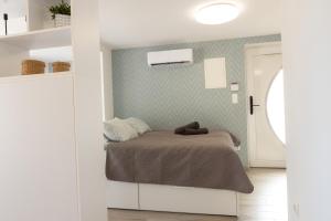 a bedroom with a bed in a white room at Kardos Villa in Szigliget