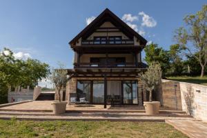 a house with a roof with a patio at Kardos Villa in Szigliget