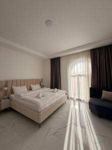 a white bedroom with a large bed and a window at Gabala Palm Villa in Gabala