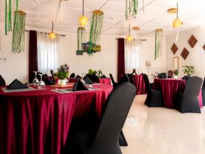 a dining room with red tables and black chairs at La Planete Hotel in Rubavu