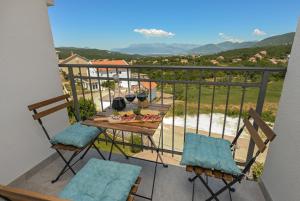 a balcony with a table with two glasses of wine at Green Oasis Residence in Radanovići +35 photos