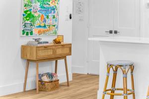 a table and two stools in a kitchen with a painting at The Beach Villa in Juno! 1-Steps to the Beach in Juno Beach