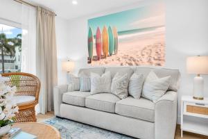 a living room with a couch and surfboards on the wall at The Beach Villa in Juno! 1-Steps to the Beach in Juno Beach +50 photos